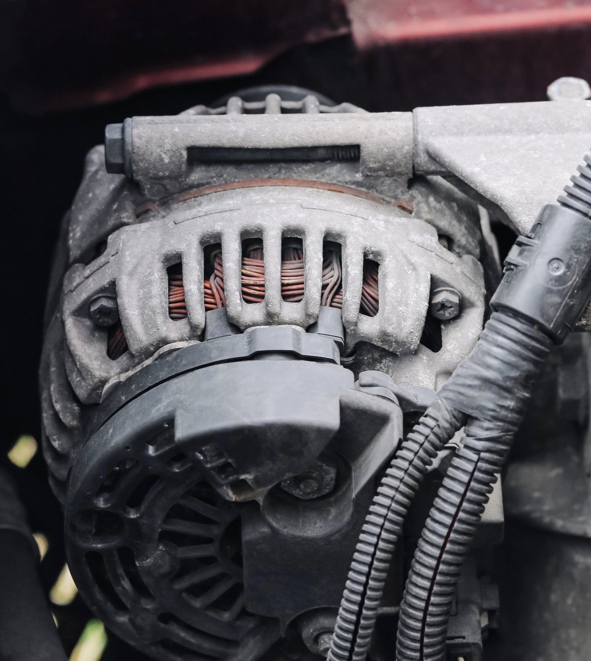 Close-up of an alternator mounted in a car engine bay
