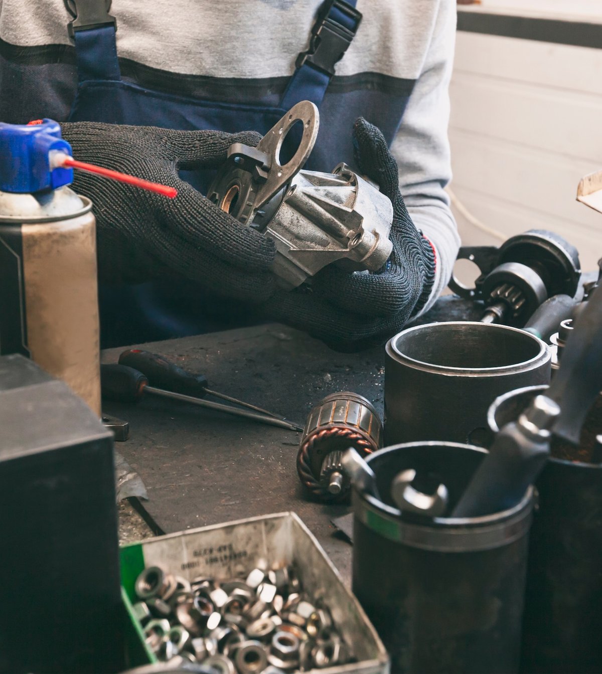 Mechanic rebuilding a starter motor at a workshop bench