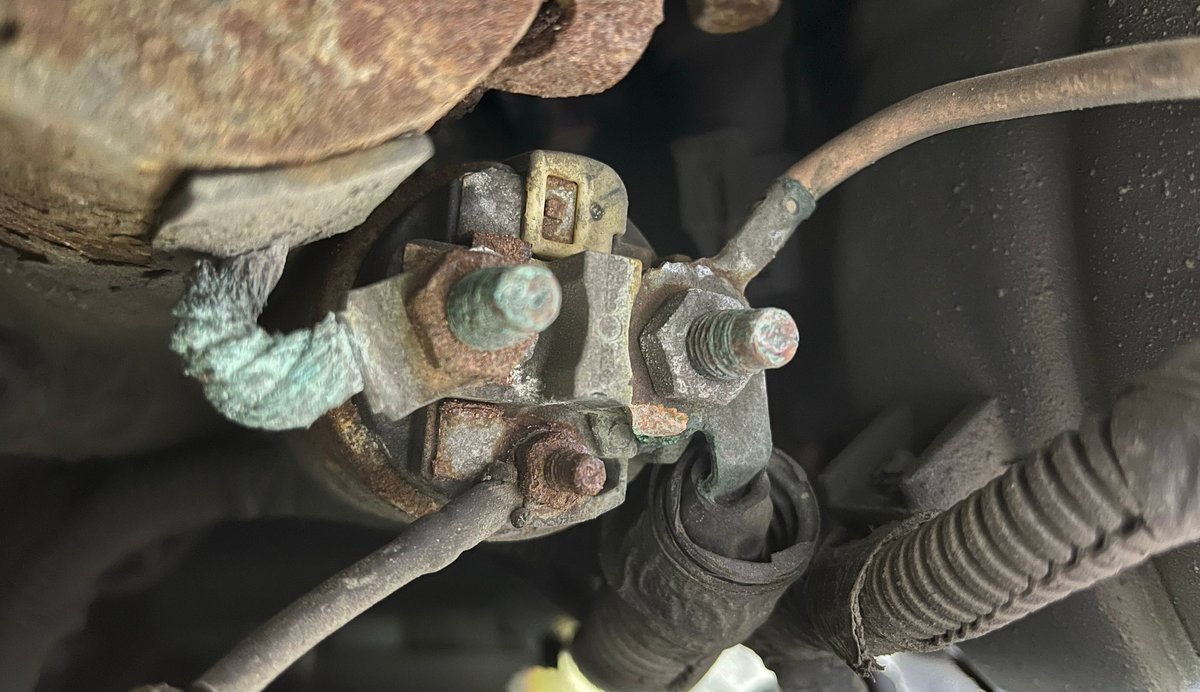 Close-up of corroded starter solenoid terminals and cable connections