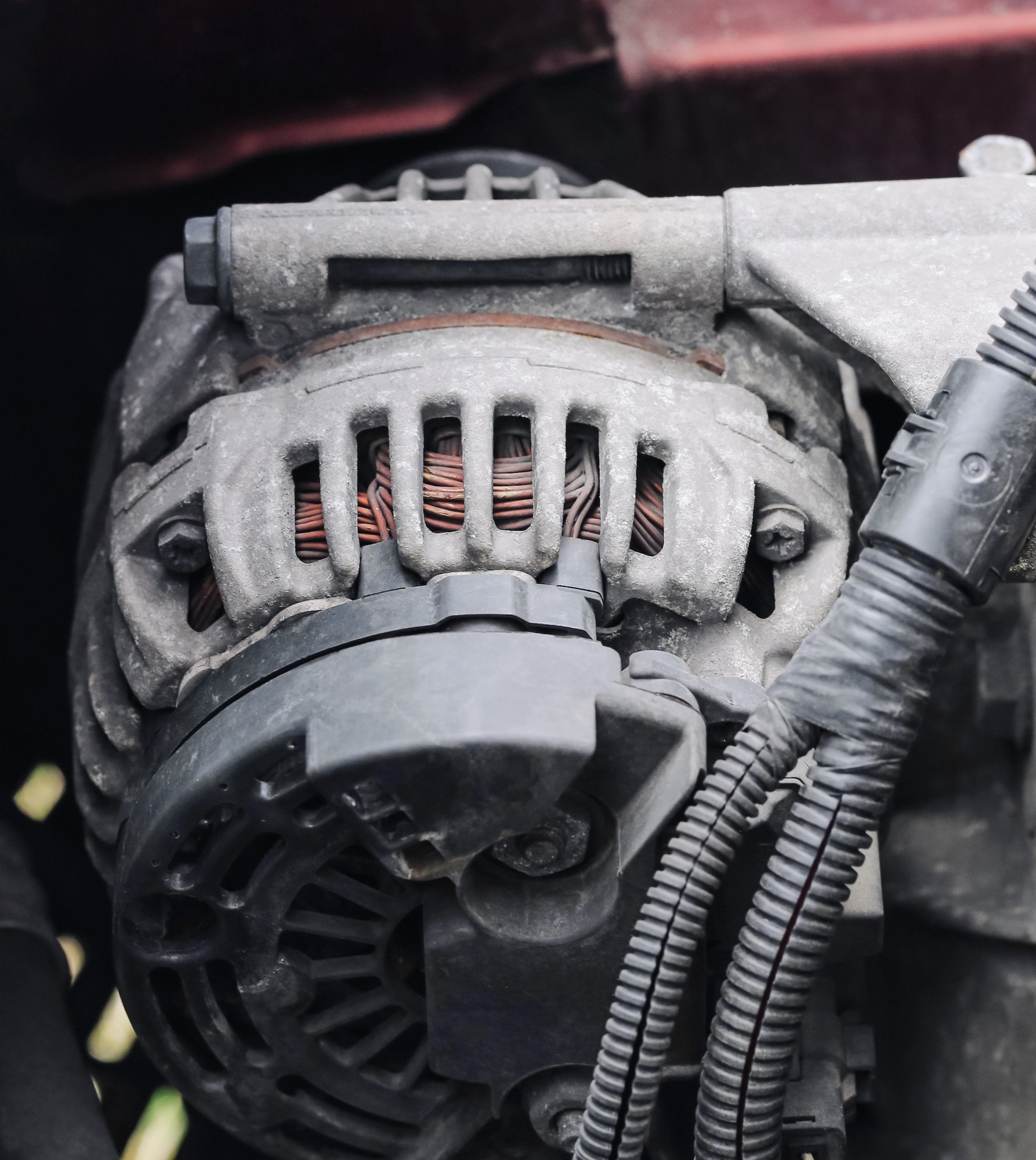 Close-up of an alternator mounted in a car engine bay