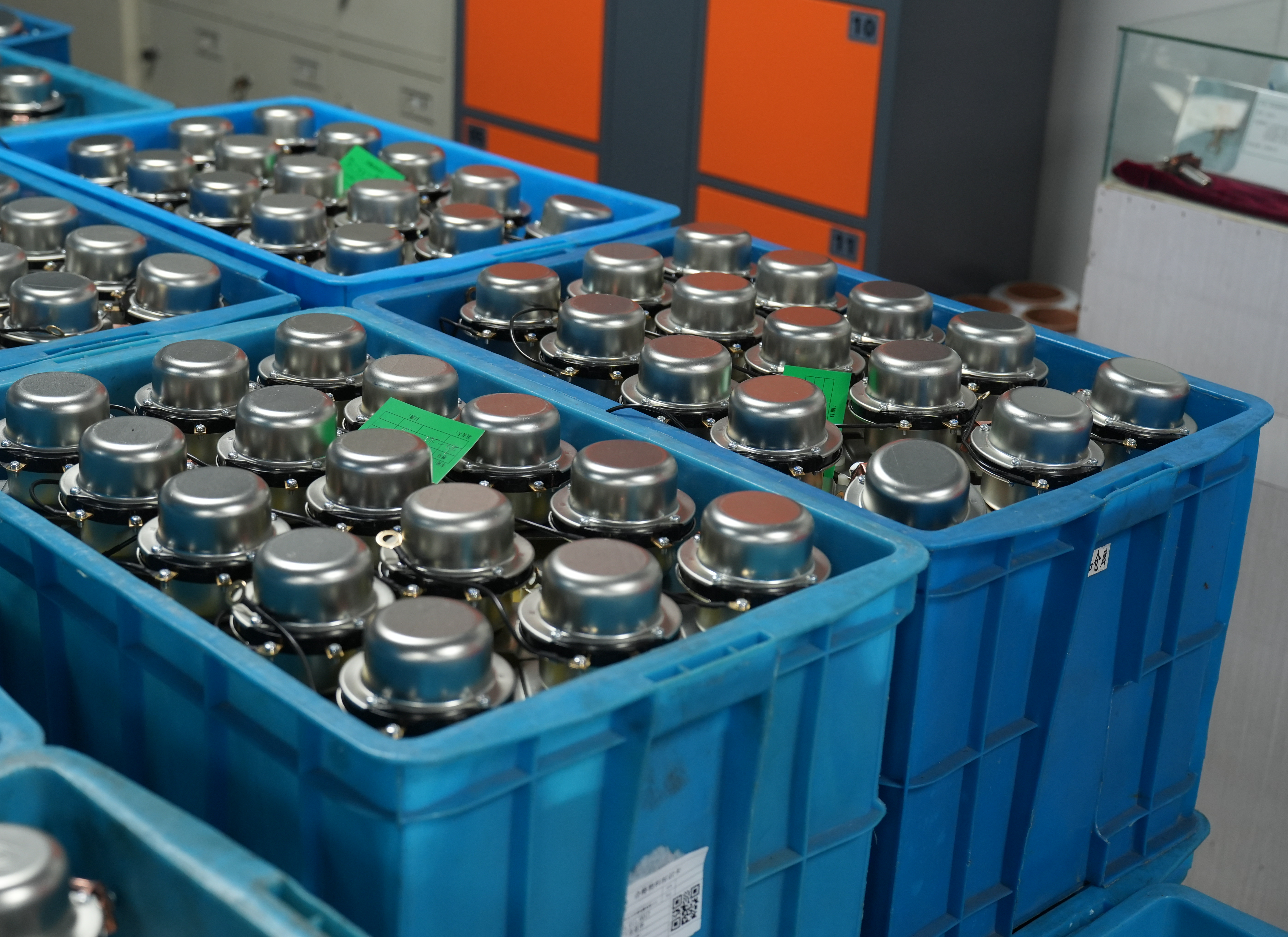 Finished battery relays organized in blue storage bins