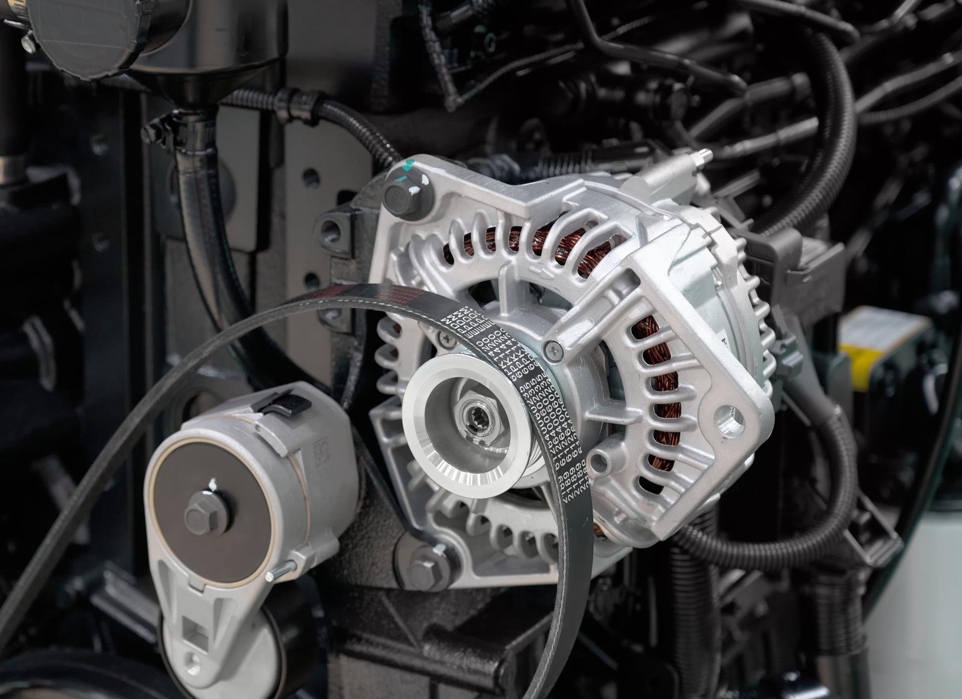 New alternator installed with the serpentine belt in a car engine