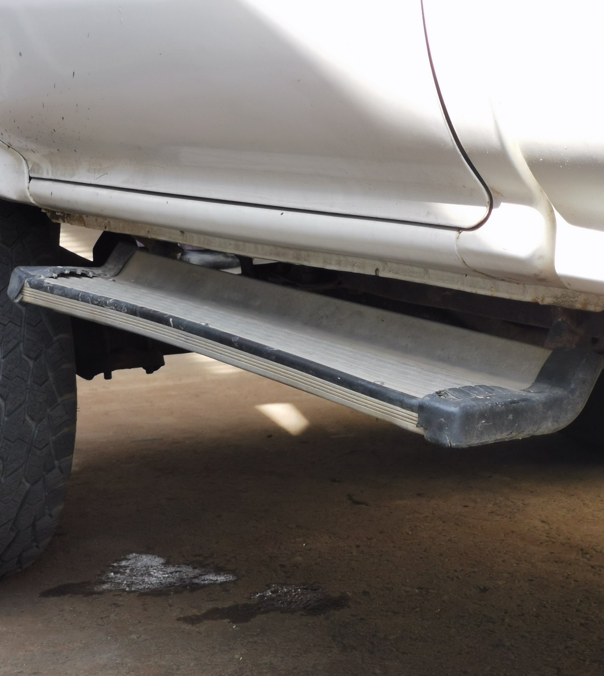 Close-up of a pickup truck tire and metal side step